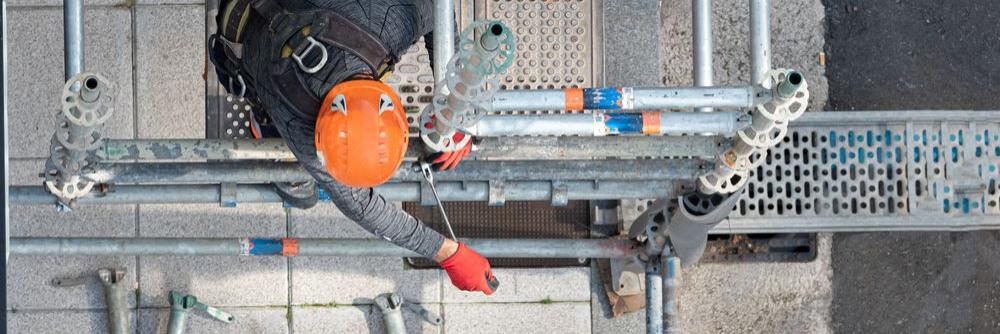 Ein Gerüstbauer arbeitet an dem Gerüst